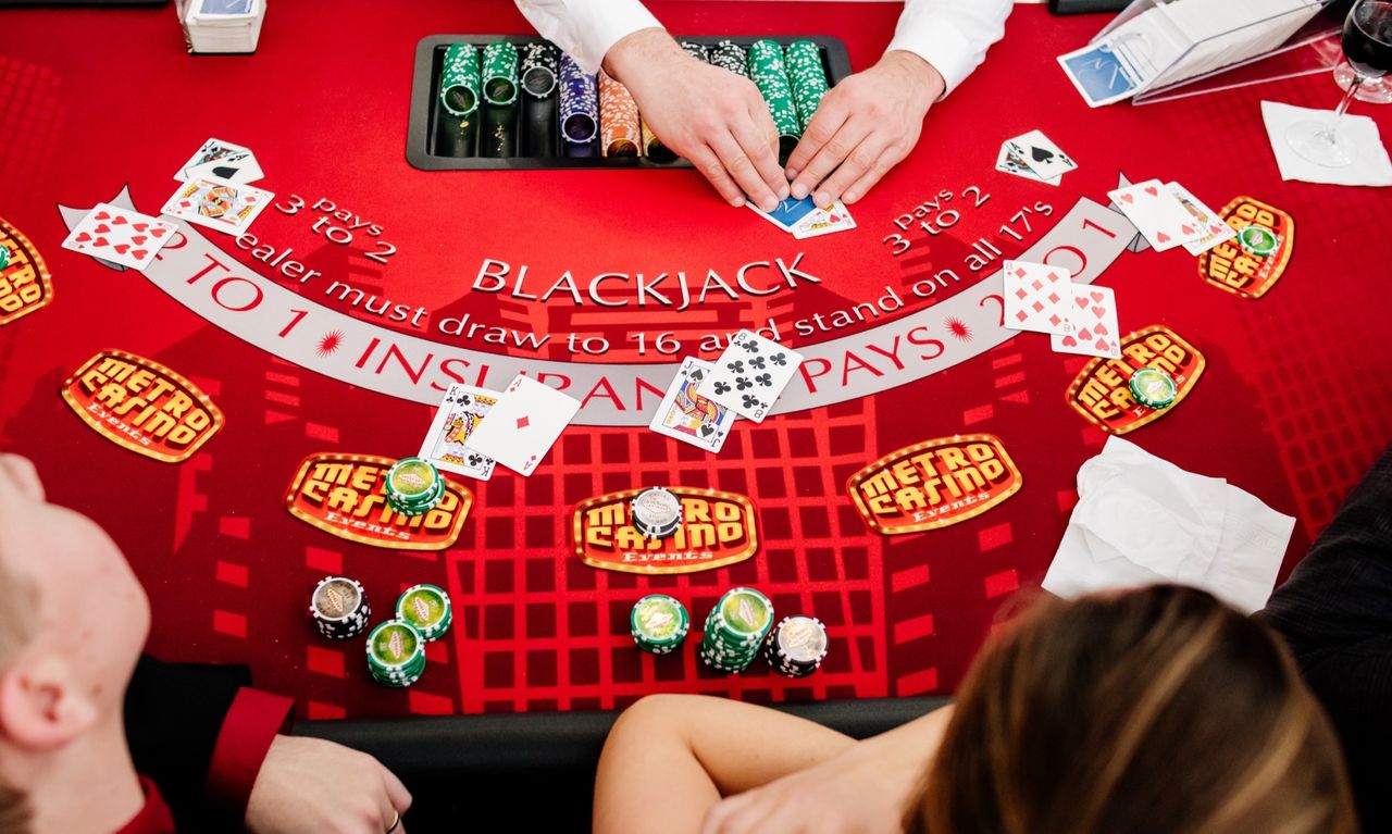 Blackjack table with cards, chips, and Metro Casino fun money