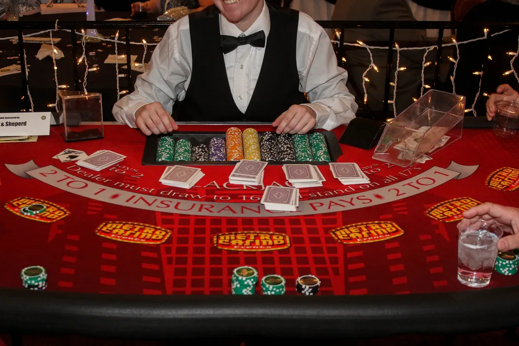 Casino dealer seated behind a branded blackjack table