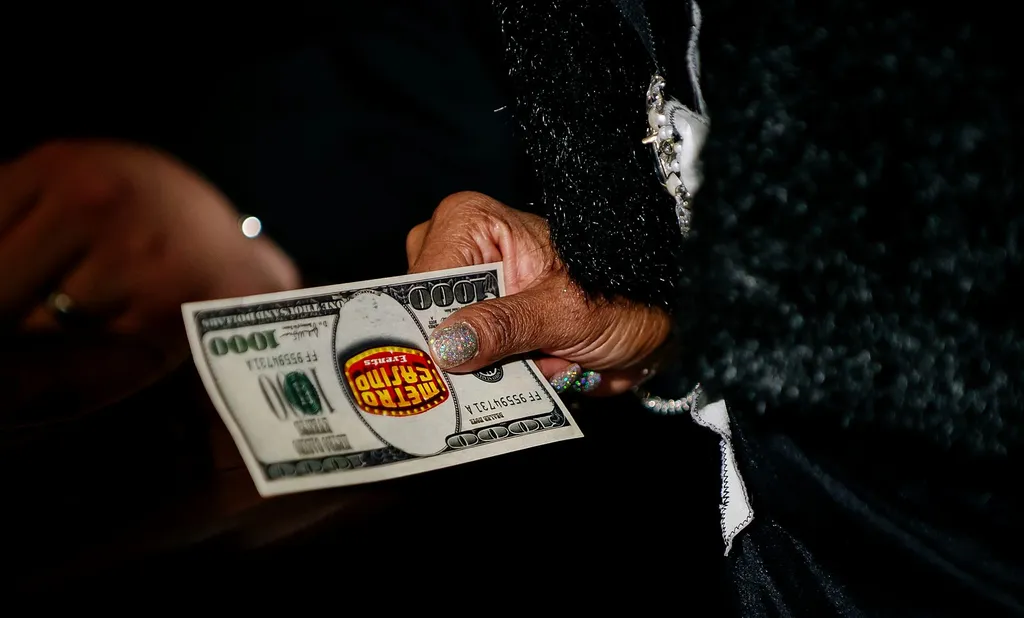 Guest holding a Metro Casino Events fun-money bill