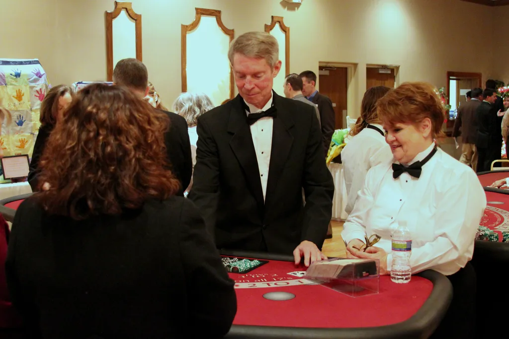 Casino dealers welcoming a guest at a table